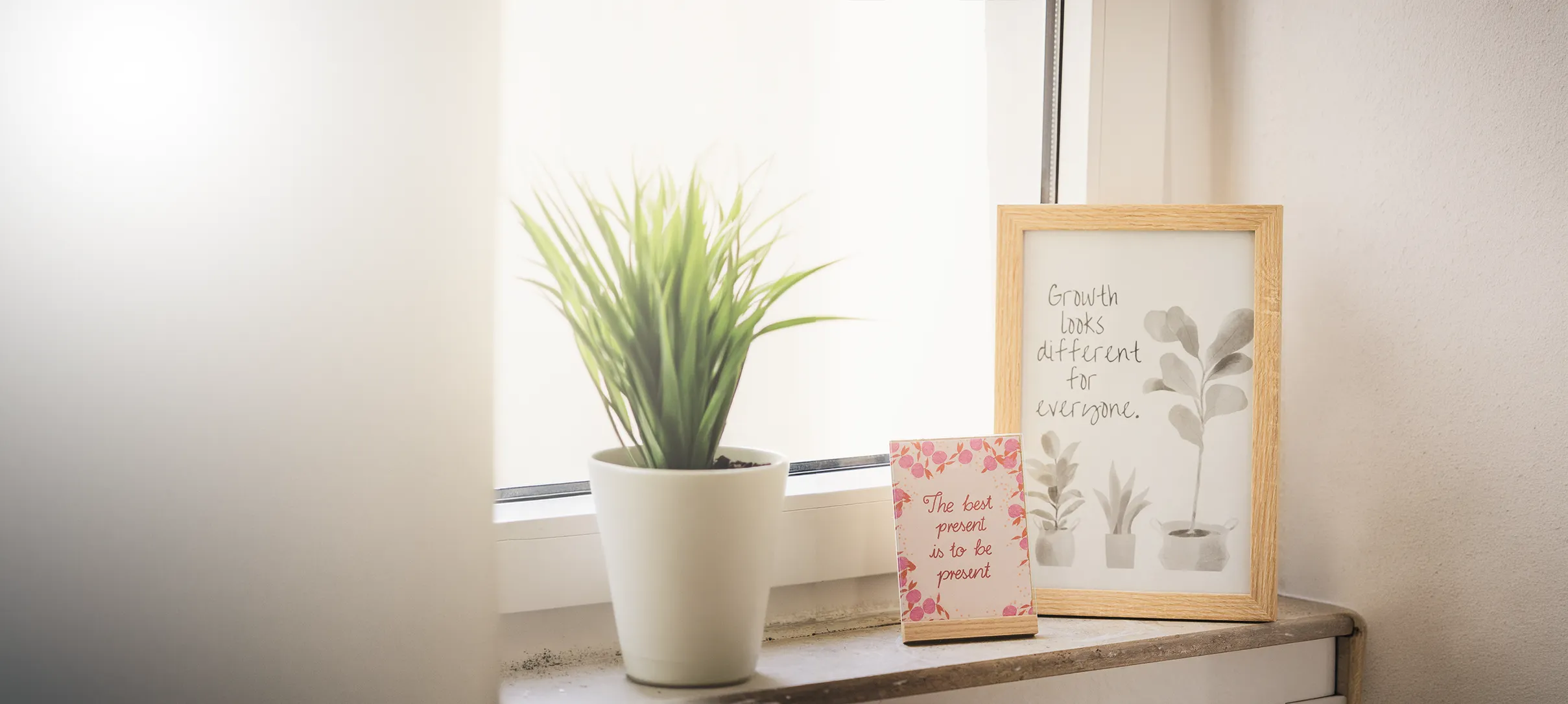 Fensterbank der Praxis mit Pflanze und gerahmten Sprüchen